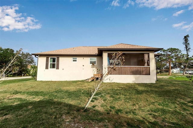 rear view of house with a lawn and a sunroom