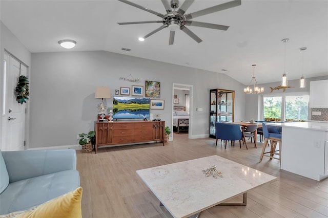 living room featuring ceiling fan with notable chandelier, light hardwood / wood-style flooring, and lofted ceiling