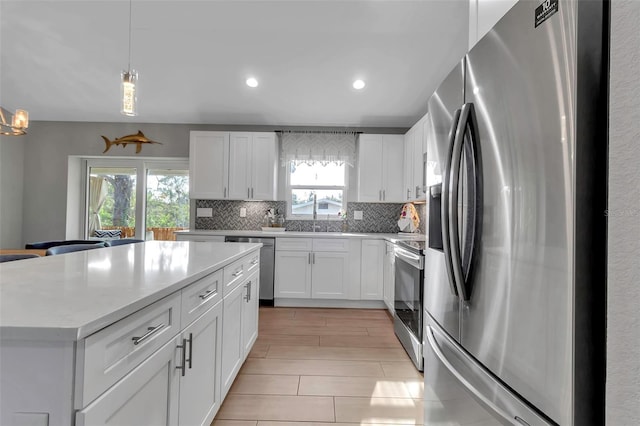 kitchen with decorative backsplash, white cabinetry, pendant lighting, and stainless steel appliances