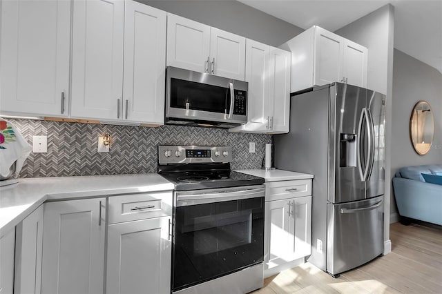 kitchen featuring white cabinets, light hardwood / wood-style floors, stainless steel appliances, and tasteful backsplash