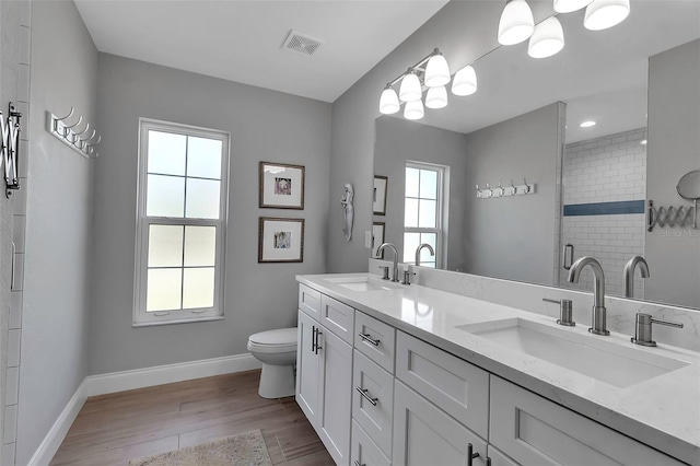 bathroom featuring hardwood / wood-style floors, vanity, toilet, and walk in shower