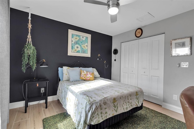 bedroom with hardwood / wood-style floors, ceiling fan, and a closet