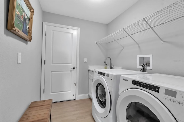 washroom featuring cabinets, independent washer and dryer, light hardwood / wood-style flooring, and sink