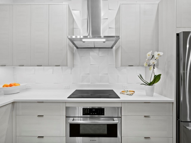 kitchen with modern cabinets, wall chimney range hood, stainless steel appliances, and light countertops