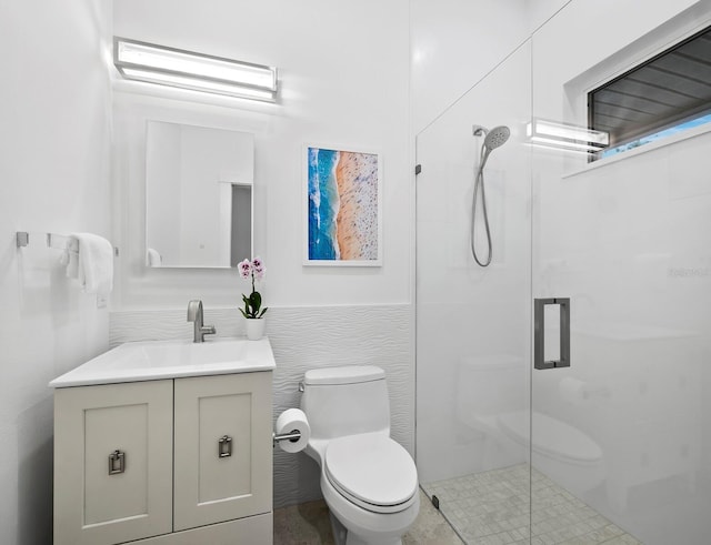 bathroom featuring vanity, a shower stall, and toilet