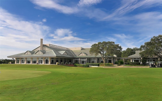 back of house with a lawn and golf course view