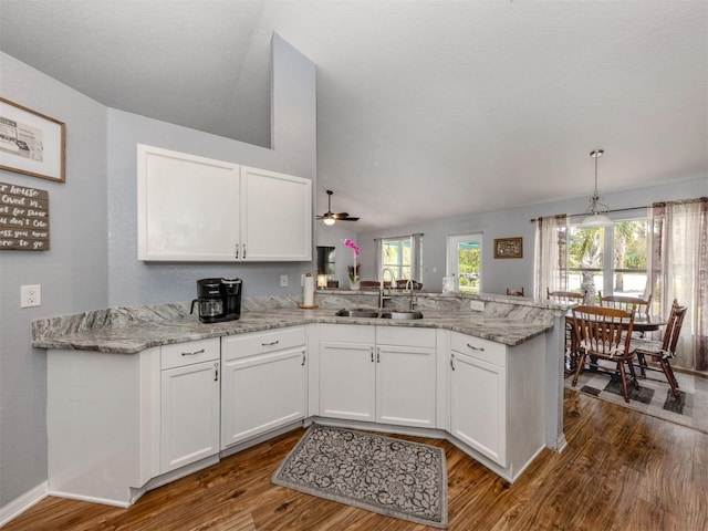 kitchen featuring sink, white cabinets, kitchen peninsula, and wood-type flooring