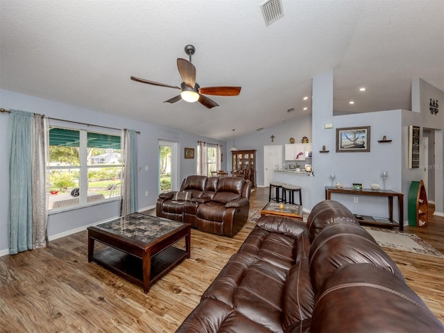 living room featuring hardwood / wood-style floors, a wealth of natural light, and vaulted ceiling