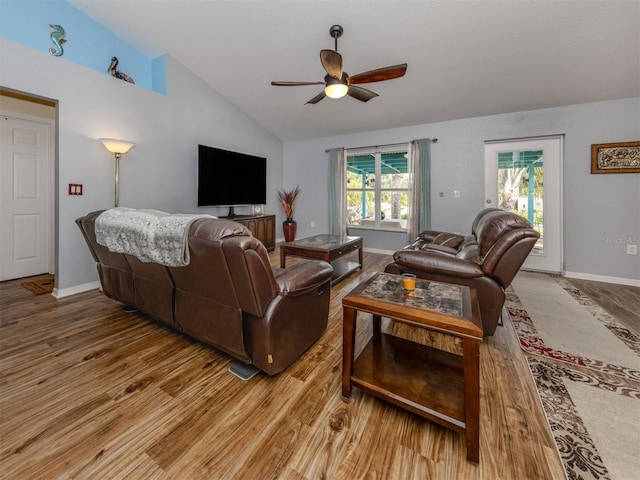 living room featuring ceiling fan, light hardwood / wood-style floors, and lofted ceiling