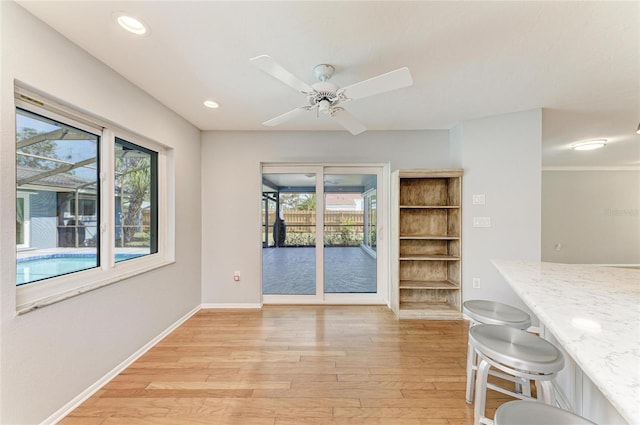 unfurnished dining area featuring a healthy amount of sunlight, light wood finished floors, baseboards, and recessed lighting