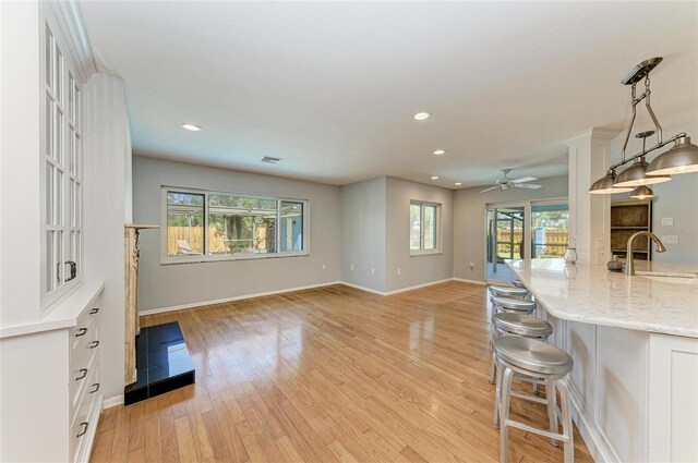 interior space with light wood finished floors, a sink, and recessed lighting