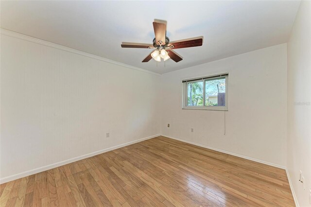 empty room featuring a ceiling fan, light wood-style flooring, and baseboards