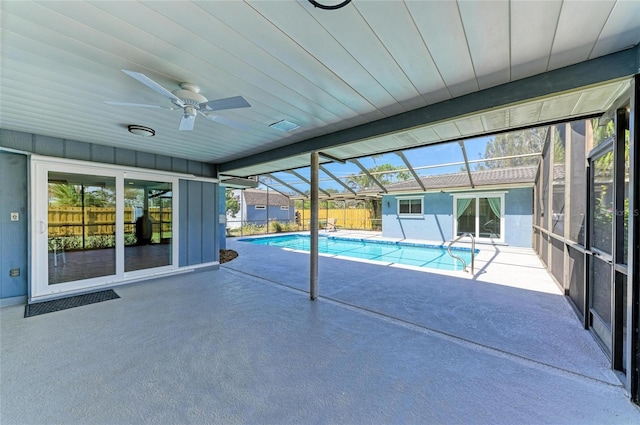 view of pool featuring a fenced in pool, glass enclosure, a patio, and a ceiling fan