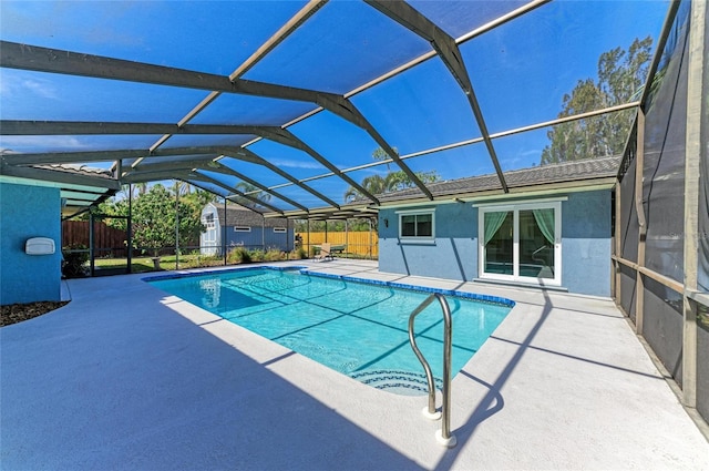 view of pool featuring glass enclosure, a patio area, and fence