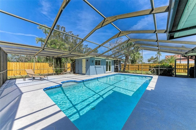 view of pool with a patio, a fenced backyard, and a lanai