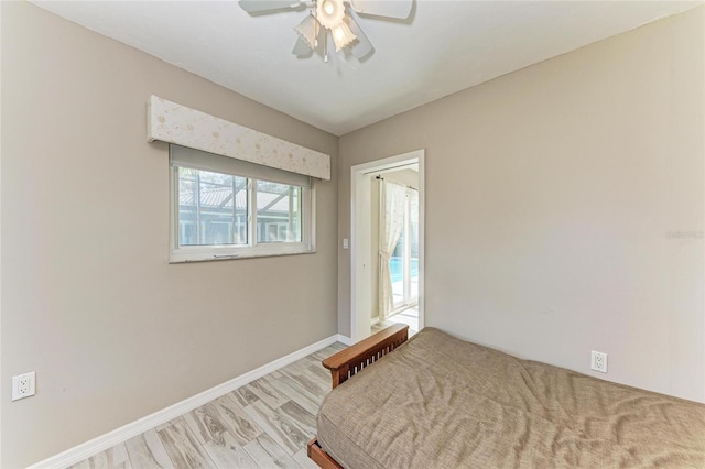 unfurnished bedroom with ceiling fan, light wood-type flooring, and baseboards