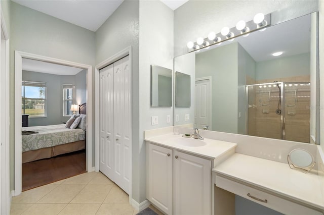 bathroom featuring vanity, a shower with door, and tile patterned flooring