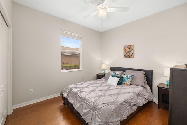 bedroom with dark wood-type flooring, ceiling fan, and a closet