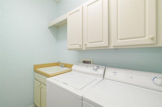 laundry room with cabinets, washer and dryer, and sink