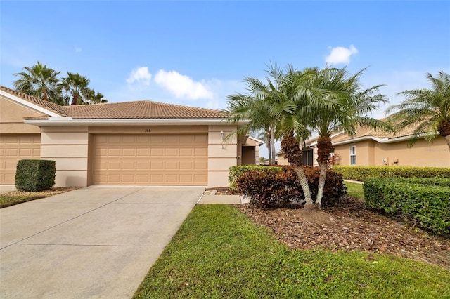 view of front of home with a garage, driveway, a tiled roof, and stucco siding