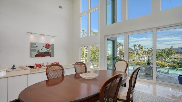 dining space with tile patterned flooring and a towering ceiling