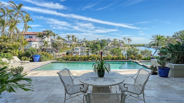 view of pool with a patio area and a water view