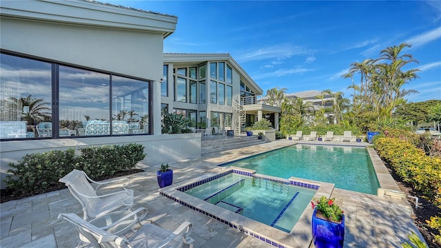 view of pool with a patio area and an in ground hot tub