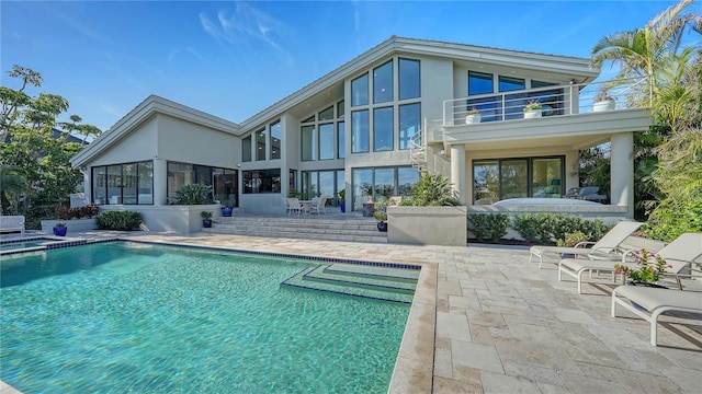 rear view of house featuring a patio and a balcony