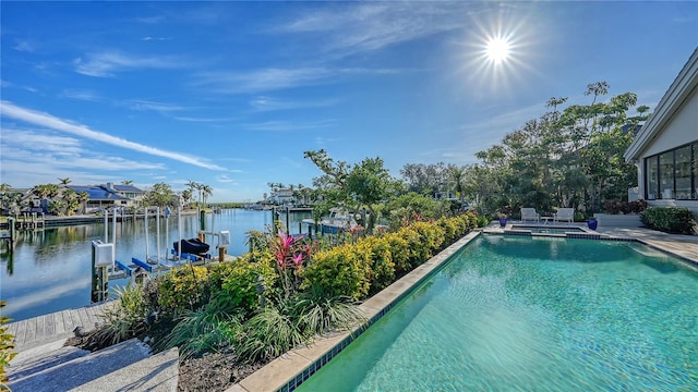 view of swimming pool featuring a dock and a water view