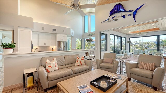 living room featuring a high ceiling, wood ceiling, and ceiling fan