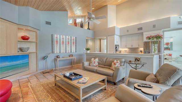 tiled living room with ceiling fan, a towering ceiling, and wood ceiling