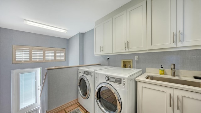 washroom featuring sink, washer and clothes dryer, and cabinets