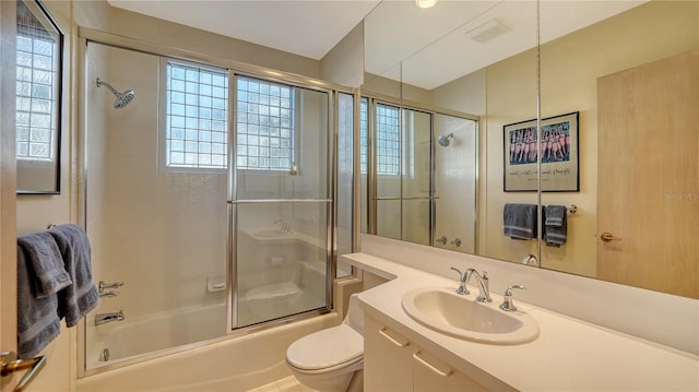 full bathroom with vanity, shower / bath combination with glass door, and toilet