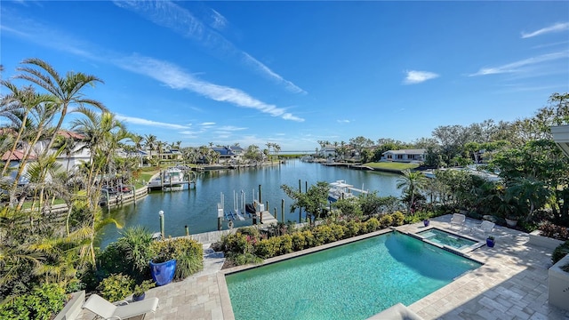 view of swimming pool featuring an in ground hot tub, a water view, and a patio area