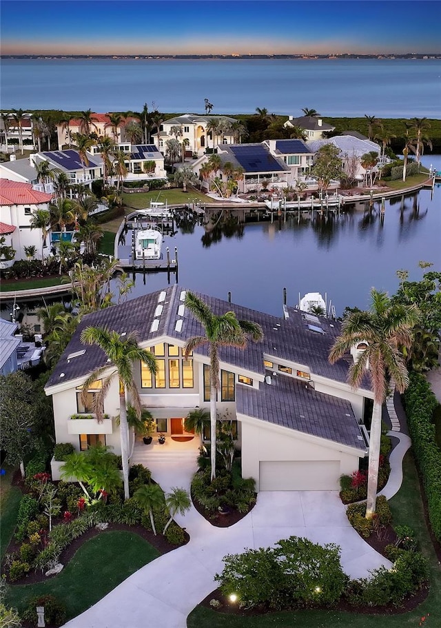 aerial view at dusk featuring a water view