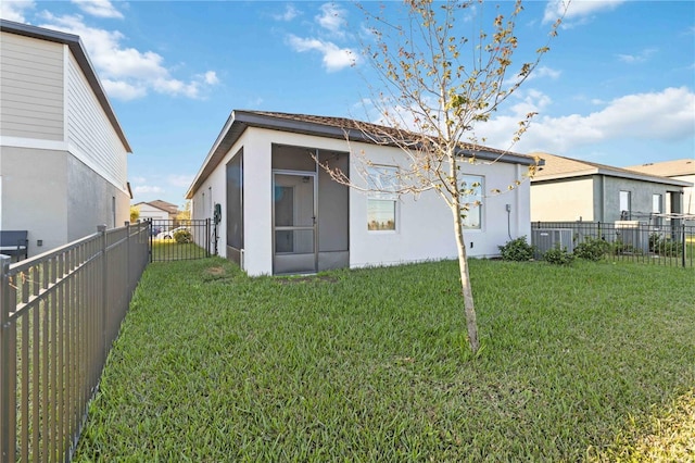 rear view of property featuring a yard and a sunroom