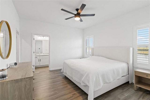 bedroom featuring ceiling fan, ensuite bathroom, sink, and dark hardwood / wood-style floors