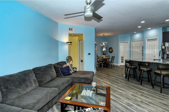 living room with ceiling fan, wood-type flooring, and sink