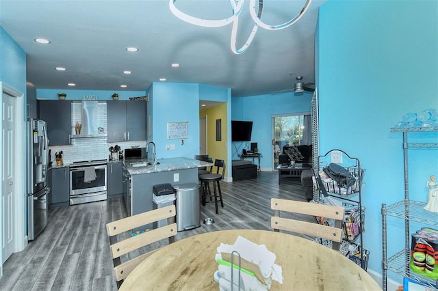 dining area featuring dark hardwood / wood-style flooring, ceiling fan, and sink