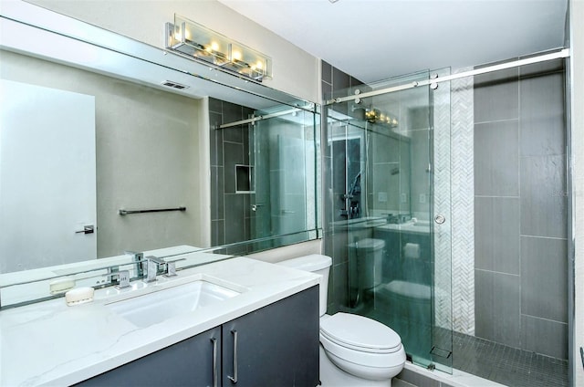 bathroom with toilet, vanity, and walk in shower