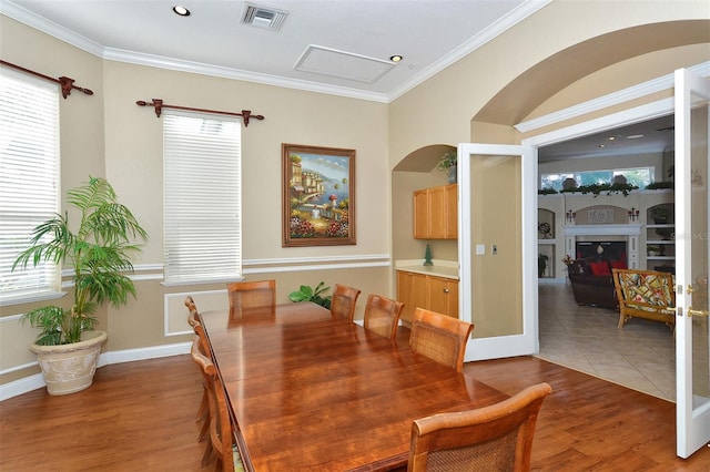 dining area featuring wood-type flooring and ornamental molding