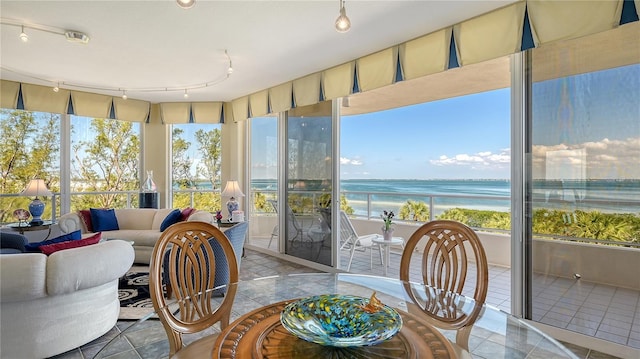 sunroom / solarium with track lighting and a water view