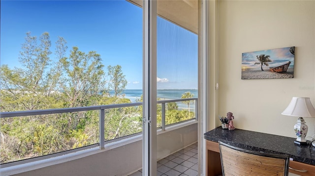 sunroom featuring a water view