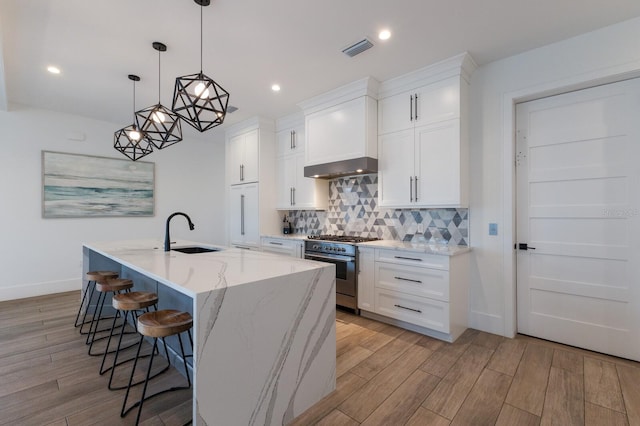 kitchen with sink, stainless steel stove, and white cabinets