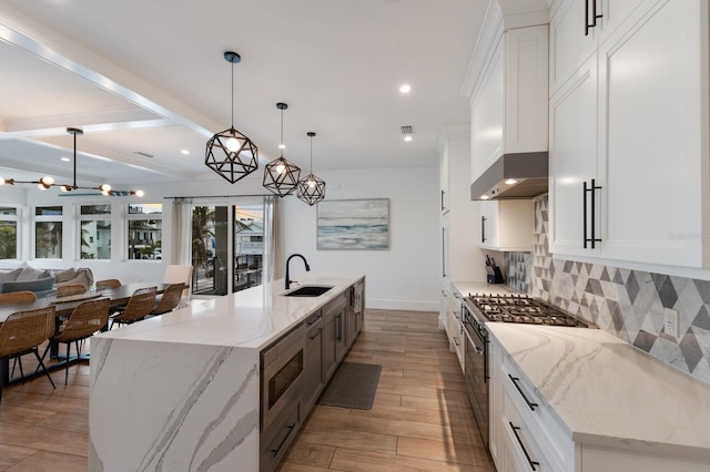 kitchen with decorative light fixtures, appliances with stainless steel finishes, white cabinetry, and a large island