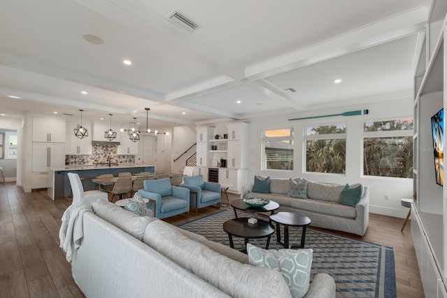 living room with sink, dark hardwood / wood-style floors, ornamental molding, and beam ceiling