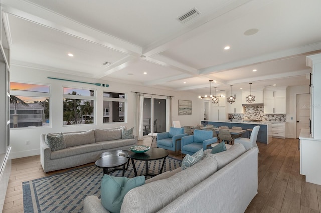 living room with beam ceiling, a notable chandelier, coffered ceiling, and light hardwood / wood-style flooring