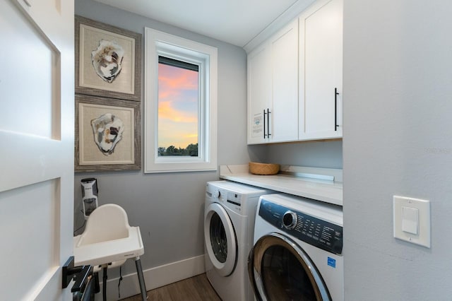 washroom featuring washer and dryer, hardwood / wood-style flooring, and cabinets