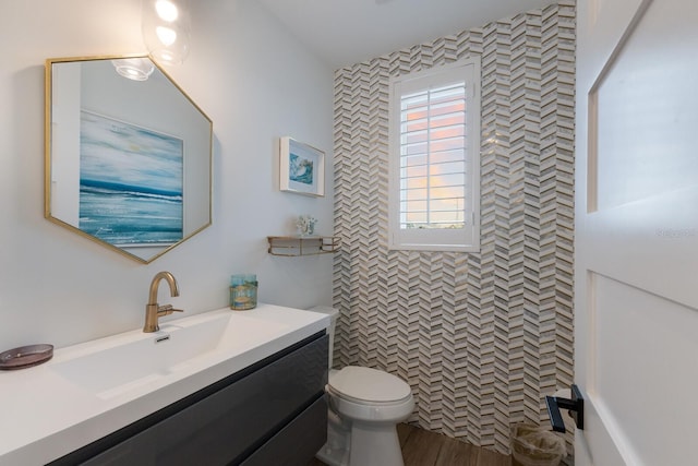 bathroom featuring toilet, vanity, and a shower