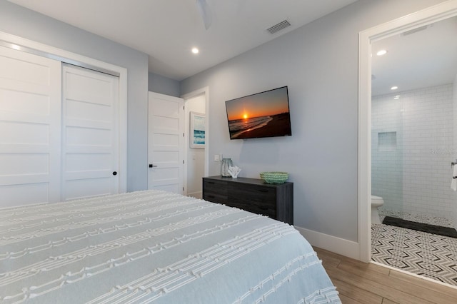 bedroom with a closet, ensuite bathroom, and ceiling fan